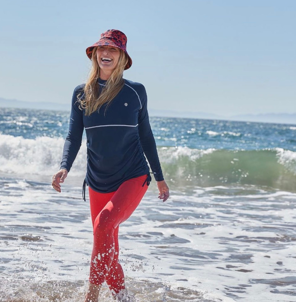 woman smiling walking through ocean waves