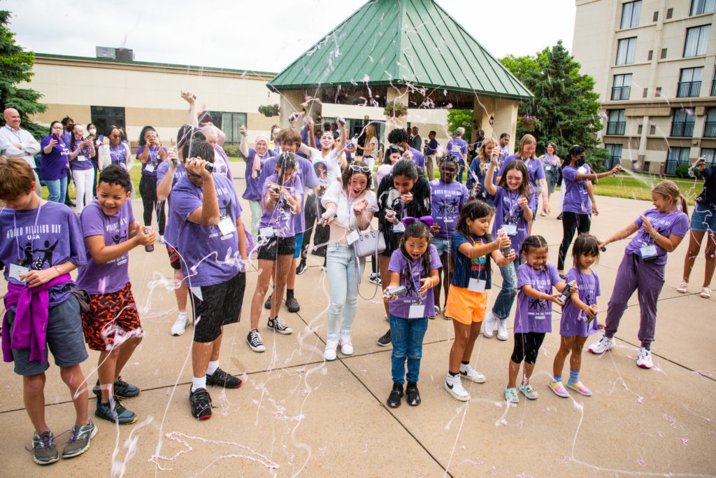 A group of children play with silly string