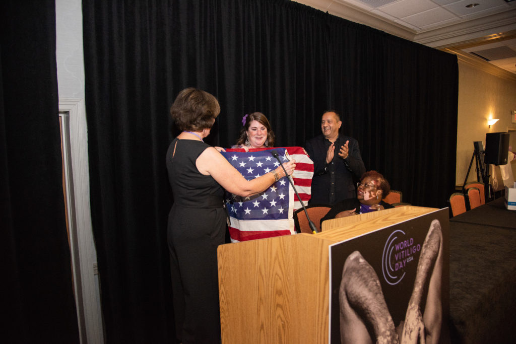 Woman with vitiligo is presented with US flag